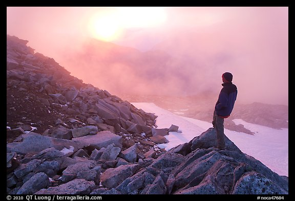 Visitor on ridge waches foggy sunset, North Cascades National Park. Washington, USA.