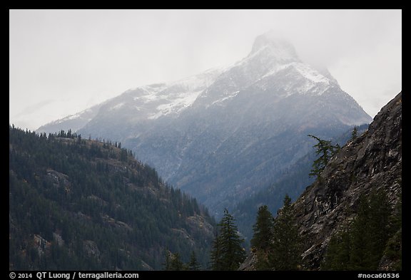 Snow-capped jagged peak in clouds, North Cascades National Park. Washington, USA.