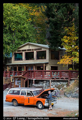 Man fixing old car in front of North Cascades Lodge, Stehekin, North Cascades National Park Service Complex. Washington, USA.