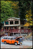 Man fixing old car in front of North Cascades Lodge, Stehekin, North Cascades National Park Service Complex.  ( color)