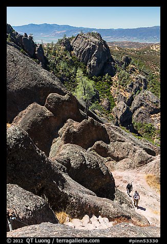 Hikers approaching cliff with steps carved in stone. Pinnacles National Park, California, USA.