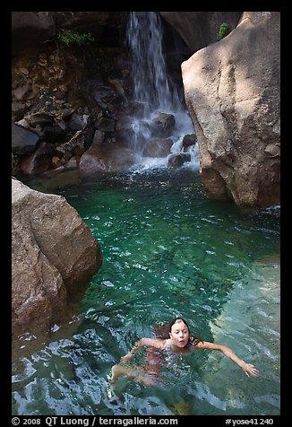 Girl swims in cool pool at the base of Wapama falls. Yosemite National Park, California, USA.