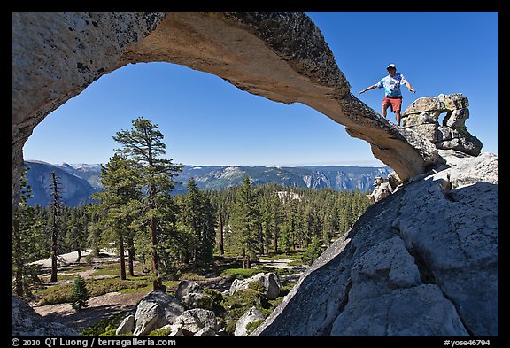 Hiker stepping on top of Indian Arch. Yosemite National Park (color)