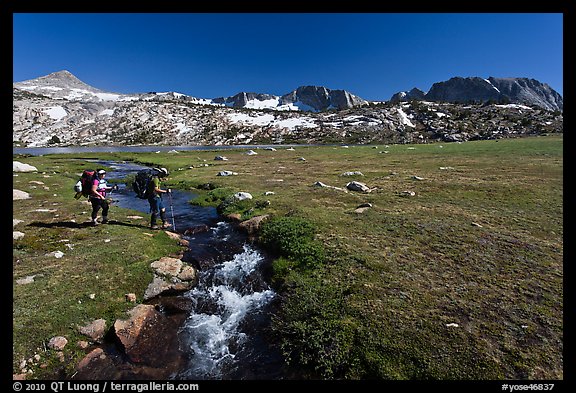 Backpackers crossing stream, Evelyn Lake. Yosemite National Park (color)