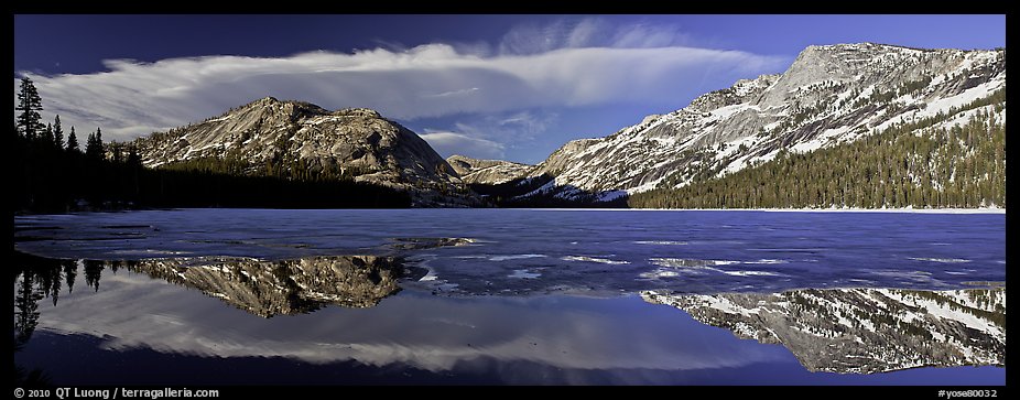 Mountains reflected in partly iced Tenaya Lake. Yosemite National Park, California, USA.