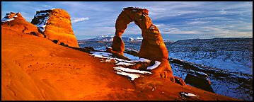 Red sandstone of Delicate Arch and blue shades of snow. Arches National Park (Panoramic color)