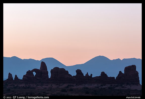 Turret Arch, spires, and mountains at dawn. Arches National Park, Utah, USA.
