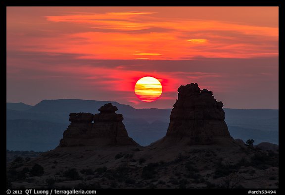 Sun setting between rock towers. Arches National Park, Utah, USA.