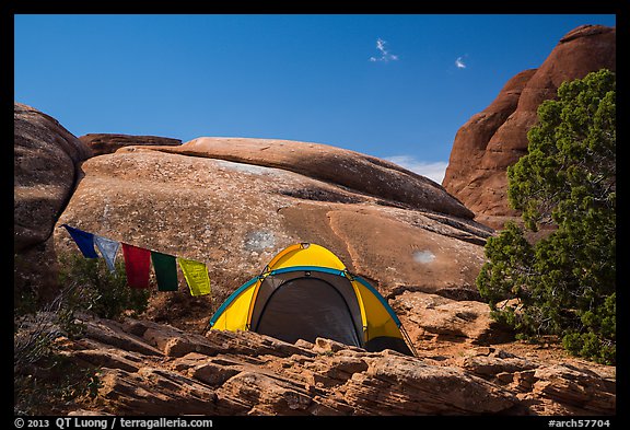 Tent with prayer flags amongst sandstone rocks. Arches National Park, Utah, USA.