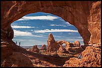 Family in the North Window span. Arches National Park, Utah, USA. (color)