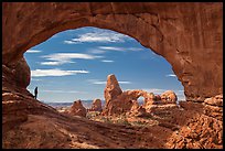 Park visitor looking, Turret Arch framed by North Window. Arches National Park, Utah, USA. (color)