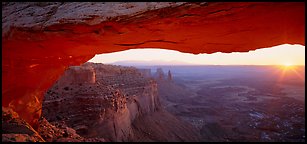 Sunrise and canyon landscape through Mesa Arch. Canyonlands National Park (Panoramic color)