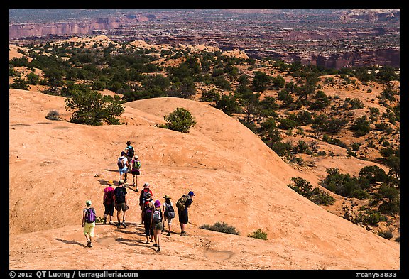 Hikers on Whale Rock. Canyonlands National Park, Utah, USA.