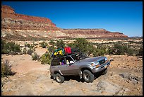 4WD vehicle driving over rocks in Teapot Canyon. Canyonlands National Park, Utah, USA. (color)