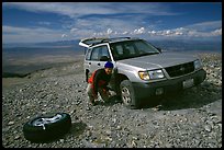 Man changing a flat tire on remote spot at top of Mt Washington. Great Basin National Park ( color)