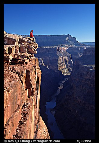 Visitor sitting on  edge of  Grand Canyon, Toroweap. Grand Canyon National Park, Arizona, USA.
