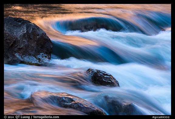 Boulders and rapids with color from canyon walls reflected. Grand Canyon National Park, Arizona, USA.