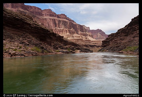 The Colorado River flows past angled strata and bright buttes. Grand Canyon National Park (color)