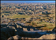 Prairie and eroded ridges stretching to horizon, early morning. Badlands National Park, South Dakota, USA.