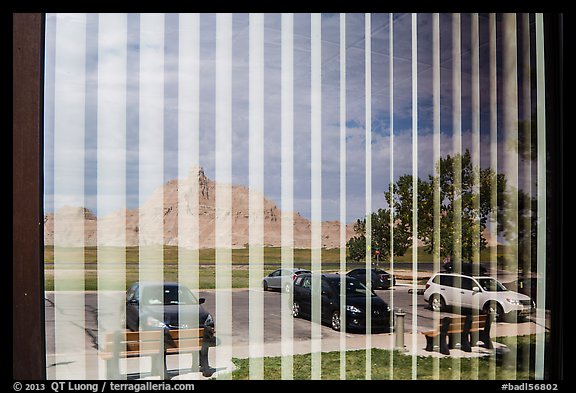 Badlands and parking lot, Visitor Center window reflexion. Badlands National Park, South Dakota, USA.