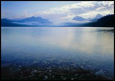 Lake McDonald with clouds and mountains reflected in early morning. Glacier National Park, Montana, USA.