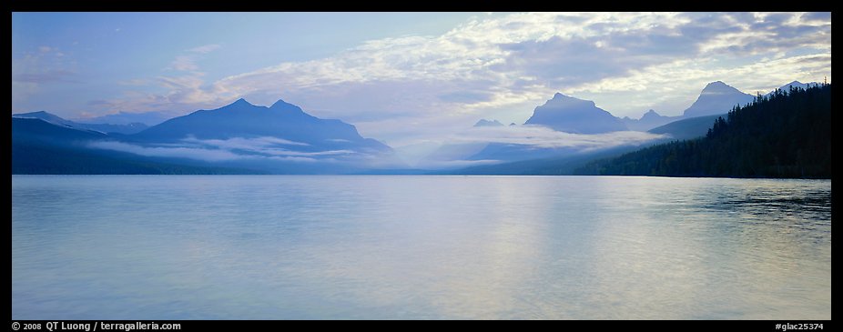 Serene lake with clouds hanging over mountains. Glacier National Park, Montana, USA.