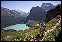 Hikers on trail overlooking Grinnell Lake. Glacier National Park, Montana, USA.