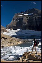 Hiker with backpack surveying Grinnell Glacier. Glacier National Park, Montana, USA.