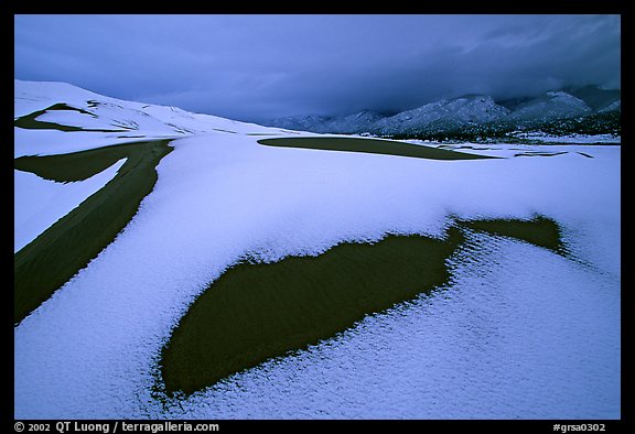 Patch of sand in snow-covered dunes. Great Sand Dunes National Park, Colorado, USA.