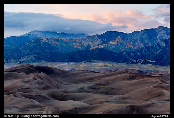Dunes and mountains with fall colors at dusk. Great Sand Dunes National Park and Preserve, Colorado, USA.