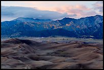 Dunes and mountains with fall colors at dusk. Great Sand Dunes National Park and Preserve, Colorado, USA.