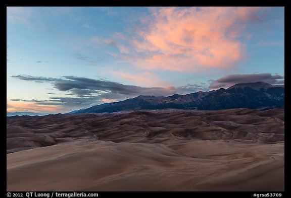 Dune field and Sangre de Cristo mountains with cloud lighted by sunset. Great Sand Dunes National Park and Preserve, Colorado, USA.