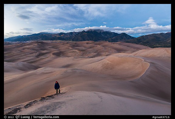 Hiker climbing high dune. Great Sand Dunes National Park and Preserve, Colorado, USA.
