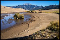 Banks of flowing Medano Creek, dunes and mountains. Great Sand Dunes National Park and Preserve ( color)