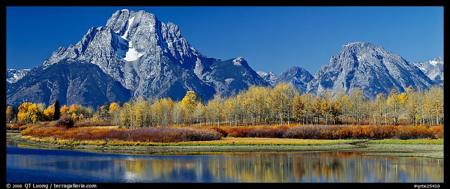Rugged mountains rising above tree-lined lake in autumn. Grand Teton National Park (color)