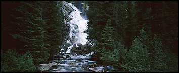 Waterfall flowing in dark forest. Grand Teton National Park (Panoramic color)