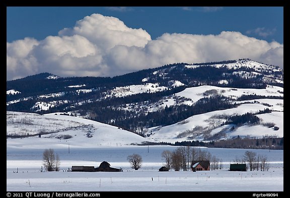 Distant row of barns, hills and clouds in winter. Grand Teton National Park, Wyoming, USA.