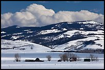 Distant row of barns, hills and clouds in winter. Grand Teton National Park, Wyoming, USA. (color)