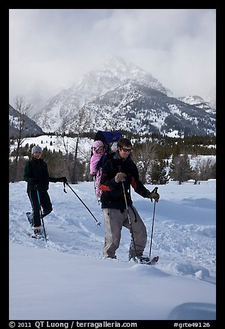 Couple snowshowing with baby. Grand Teton National Park, Wyoming, USA.