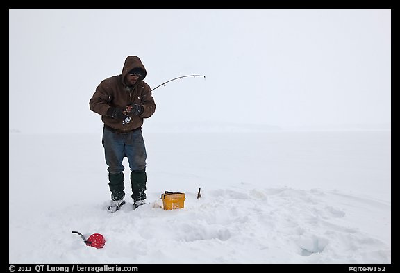 Ice fisherman standing next to hole, Jackson Lake. Grand Teton National Park (color)