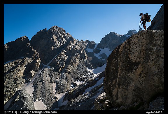 Mountaineer stands on rock looking at peaks, Garnet Canyon. Grand Teton National Park, Wyoming, USA.