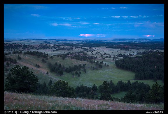 Rolling hills with distant lightening storm at dusk. Wind Cave National Park, South Dakota, USA.