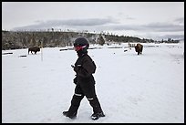 Child walking with buffaloes in the distance. Yellowstone National Park, Wyoming, USA.
