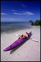 Woman sunning herself on sea kayak parked on shore,  Elliott Key. Biscayne National Park, Florida, USA. (color)