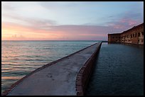 Fort Jefferson moat and walls at sunset with tourists in distance. Dry Tortugas National Park ( color)