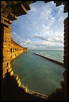 Fort Jefferson seawall and moat, framed by a crumpling embrasures, late afternoon. Dry Tortugas National Park, Florida, USA. (color)