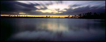 Dark clouds in motion at sunset over lake. Everglades National Park (Panoramic color)