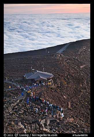 People gather to watch sunrise above sea of clouds. Haleakala National Park, Hawaii, USA.