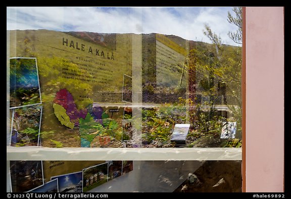Haleakala slopes and native garden with signs, Park Headquarters Visitor Center window reflexion. Haleakala National Park, Hawaii, USA.