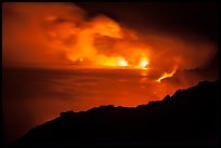 Hydrochloric steam clouds glow by lava light on coast. Hawaii Volcanoes National Park, Hawaii, USA.